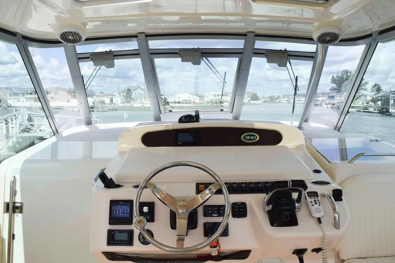 Slide: The Image of Helm of 2012 Grady-White Express 360 boat with steering wheel and navigation controls. - 11