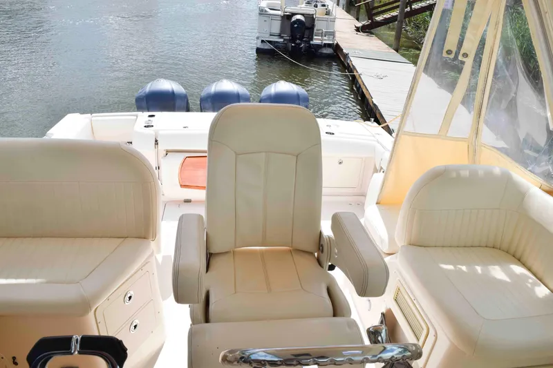 Slide: The Image of 2012 Grady-White Express 360 boat interior with beige seating and triple outboard motors. - 14
