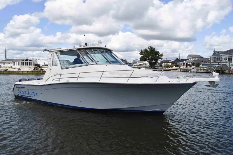 Slide: The Image of 2012 Grady-White Express 360 boat on water, under cloudy sky. - 2