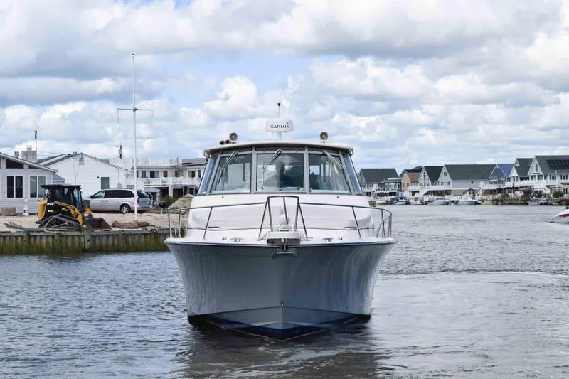 Slide: The Image of 2012 Grady-White Express 360 boat on a calm waterfront with houses in the background. - 3