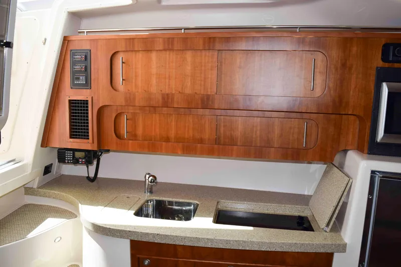 Slide: The Image of Interior of 2012 Grady-White Express 360 boat with wooden cabinets and compact kitchen area. - 40