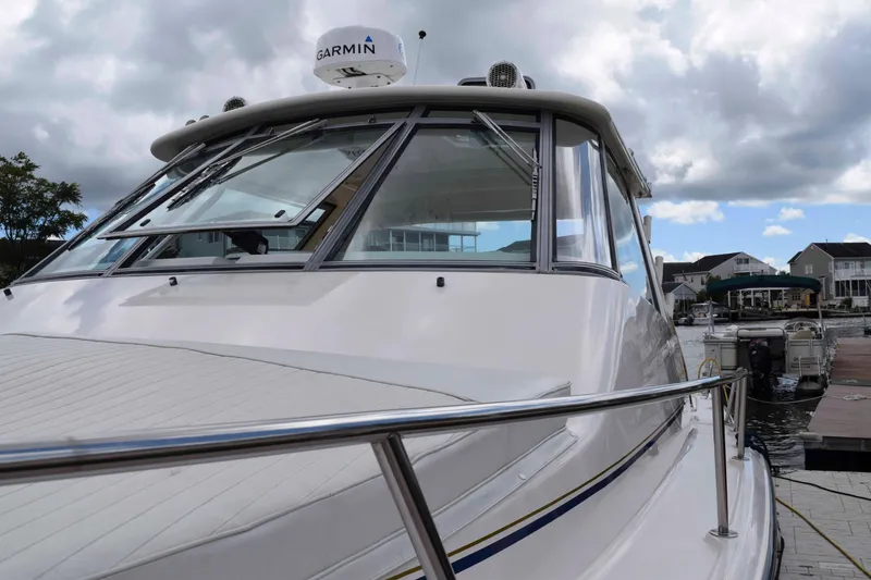 Slide: The Image of 2012 Grady-White Express 360 boat docked, featuring Garmin equipment under cloudy skies. - 5