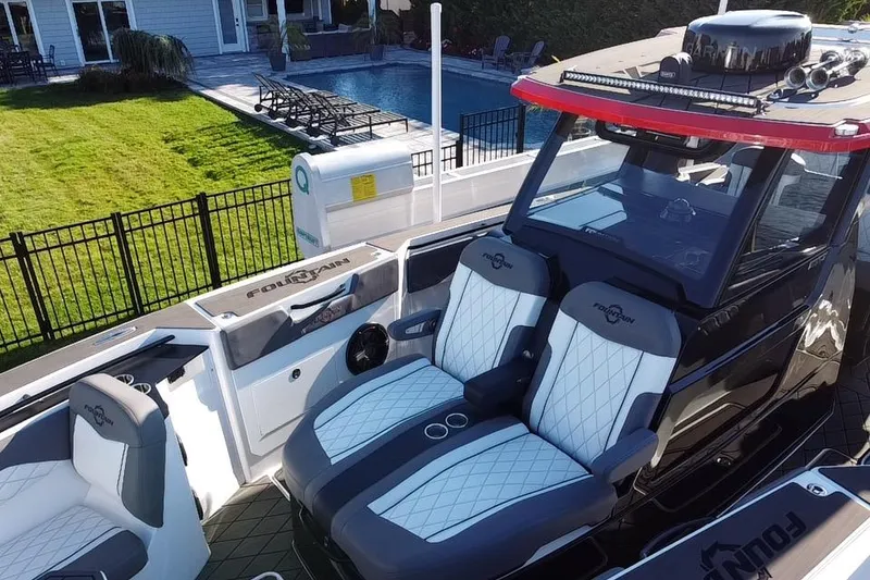 Slide: The Image of 2023 Fountain 38 SCX boat with triple 400 engines docked near waterfront homes. - 11