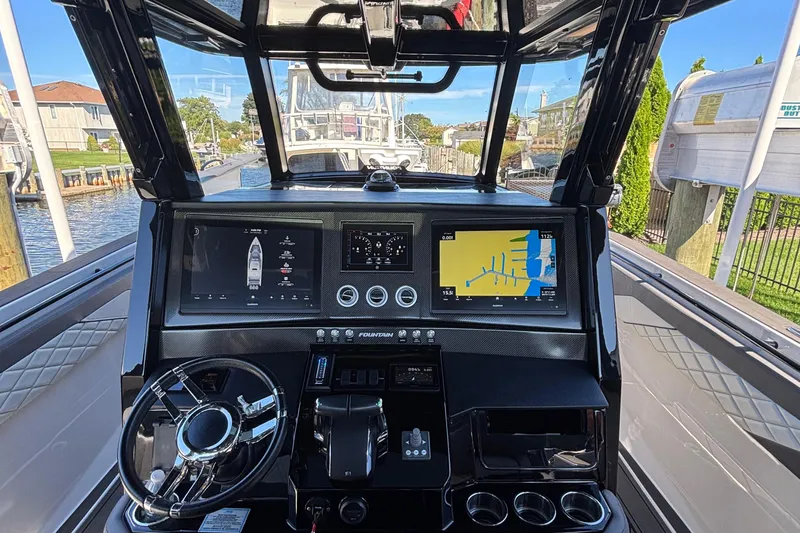 Slide: The Image of 2023 Fountain 38 SCX boat with triple 400R engines docked near waterfront homes. - 14