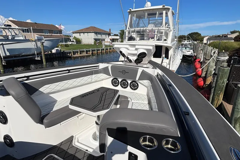 Slide: The Image of 2023 Fountain 38 SCX boat interior with modern dashboard and steering wheel at marina. - 24