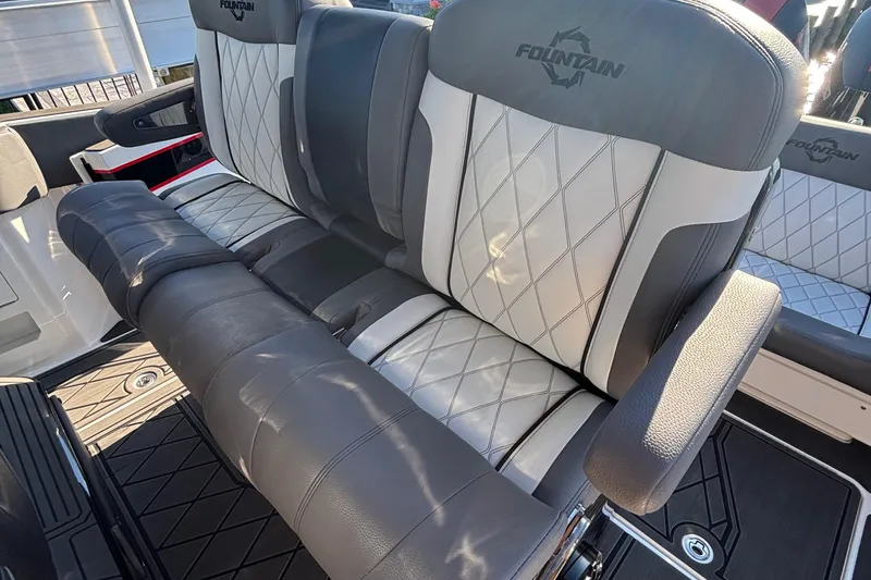 Slide: The Image of 2023 Fountain 38 SCX boat interior with seating and storage, docked by a canal. - 33