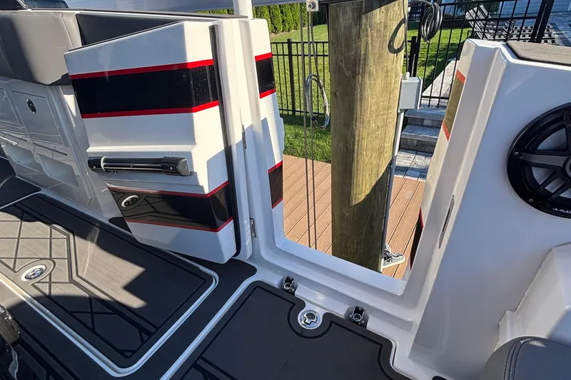 Slide: The Image of 2023 Fountain 38 SCX boat interior with seating, table, and speakers in a marina setting. - 36