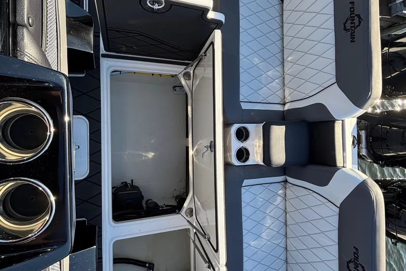 Slide: The Image of 2023 Fountain 38 SCX boat interior with luxurious seating, docked by waterfront homes. - 46