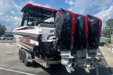 Slide: The Image of 2023 Fountain 38 SCX boat with sleek design, docked in a scenic canal setting. - 62