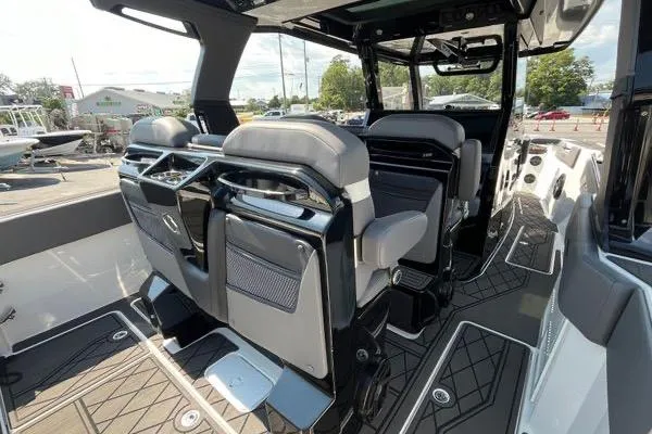 Slide: The Image of 2023 Fountain 38 SCX boat interior with covered seating area, docked in a marina. - 68