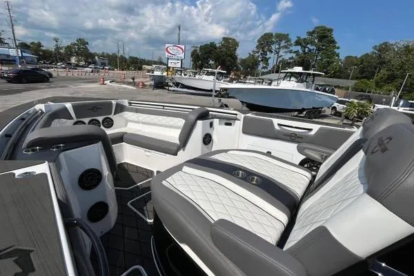 Slide: The Image of 2023 Fountain 38 SCX boat interior with seating and dashboard, parked outdoors. - 79