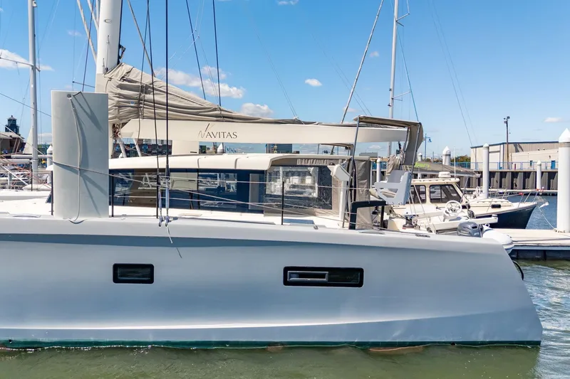 Slide: The Image of 2019 Itacatamarans 14.99 catamaran docked in a marina, viewed from the front. - 12