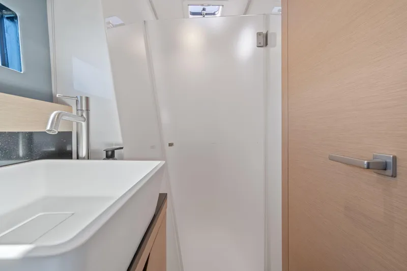 Slide: The Image of 2019 Itacatamarans 14.99 catamaran docked with inflatable boat, sunny marina setting. - 129