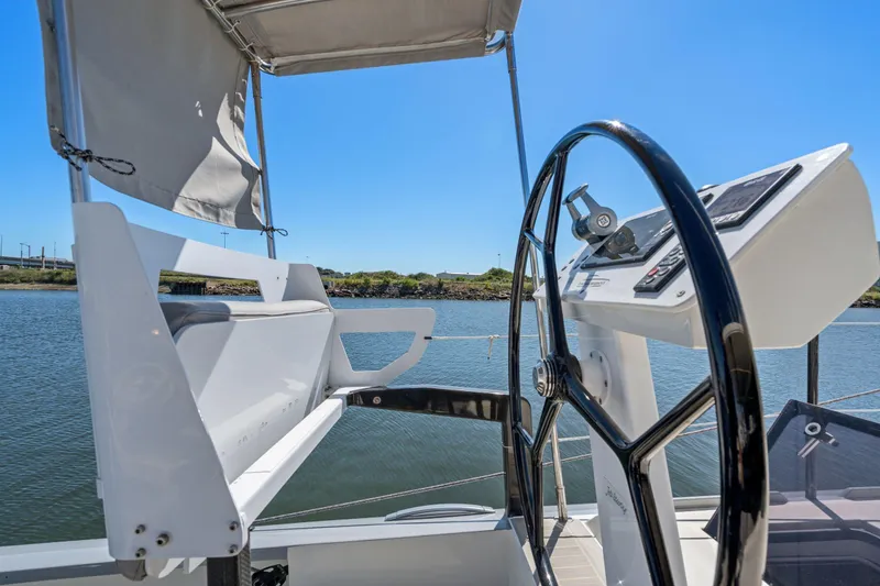 Slide: The Image of 2019 Itacatamarans 14.99 docked in a bustling marina under a clear blue sky. - 15