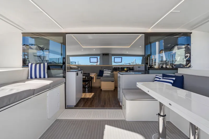 Slide: The Image of 2019 Itacatamarans 14.99 yacht deck with open storage compartment, marina background. - 162