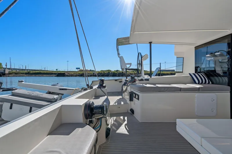 Slide: The Image of 2019 Itacatamarans 14.99 catamaran docked at marina, featuring sleek design and spacious deck. - 17