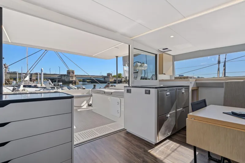 Slide: The Image of 2019 Itacatamarans 14.99 interior with seating area, table, and window view. - 46