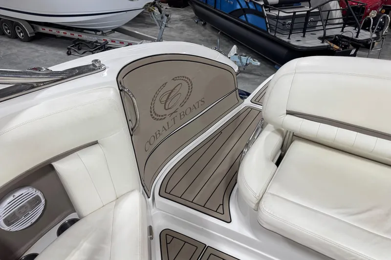 Slide: The Image of Interior of a 2007 Cobalt 323 boat with white leather seating and branded panel. - 12