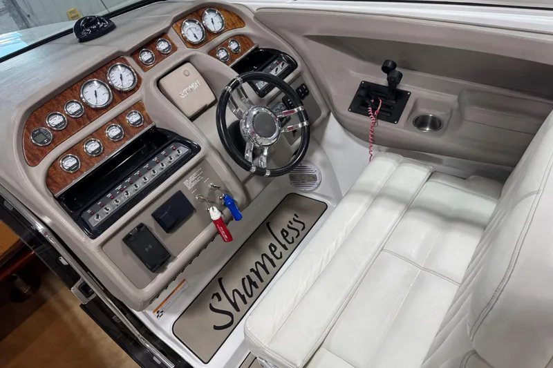 Slide: The Image of 2007 Cobalt 323 boat interior with white seating, wood-accented dashboard, and multiple gauges. - 18