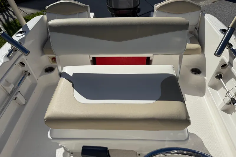 Slide: The Image of 2016 Robalo R160 Center Console boat interior with cushioned seating and steering area. - 13