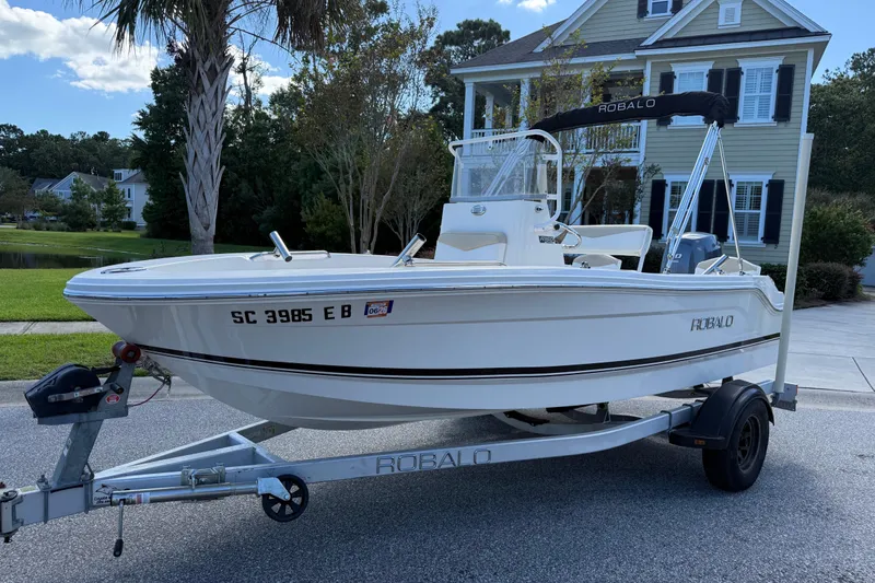 Slide: The Image of 2016 Robalo R160 Center Console boat on trailer, parked in residential area. - 2