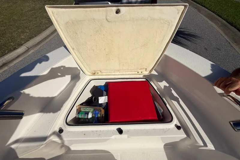 Slide: The Image of Open storage compartment on 2016 Robalo R160 Center Console boat with safety gear. - 21
