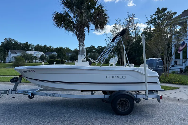 Slide: The Image of 2016 Robalo R160 Center Console boat on trailer, parked in suburban neighborhood. - 3