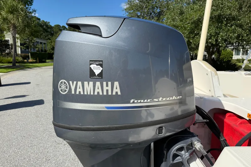 Slide: The Image of Yamaha four-stroke engine on 2016 Robalo R160 Center Console boat, parked outdoors. - 6