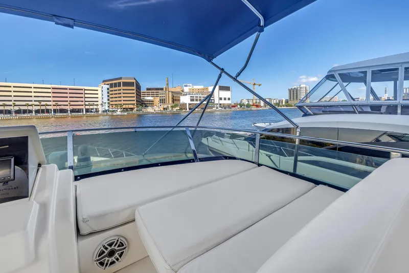 Slide: The Image of 2009 Uniesse 65 MY yacht with spacious deck, cityscape view, and blue canopy. - 25