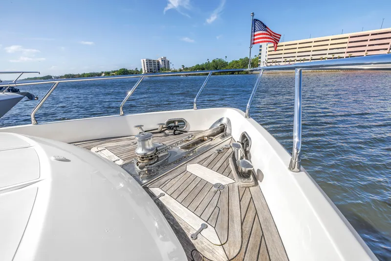 Slide: The Image of 2009 Uniesse 65 MY yacht deck with American flag, docked near waterfront buildings. - 36