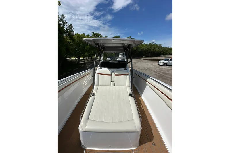 Slide: The Image of 2015 Nor-Tech 390 Sport Center Console boat with cushioned seating, under a clear blue sky. - 13