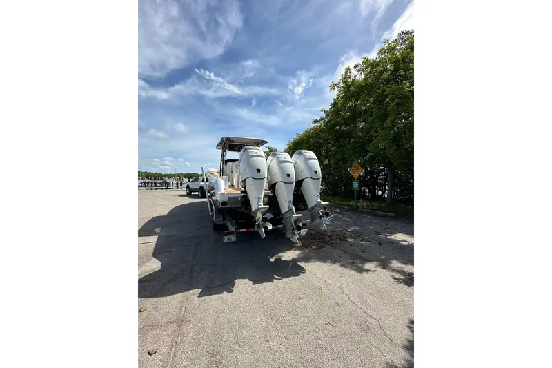 Slide: The Image of 2015 Nor-Tech 390 Sport Center Console boat with triple outboard engines on a trailer. - 16