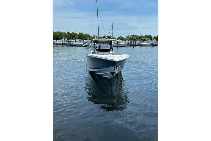 Slide: The Image of 2015 Nor-Tech 390 Sport Center Console boat on calm water, docked at marina. - 2
