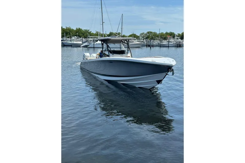 Slide: The Image of 2015 Nor-Tech 390 Sport Center Console boat on calm water, docked at a marina. - 3