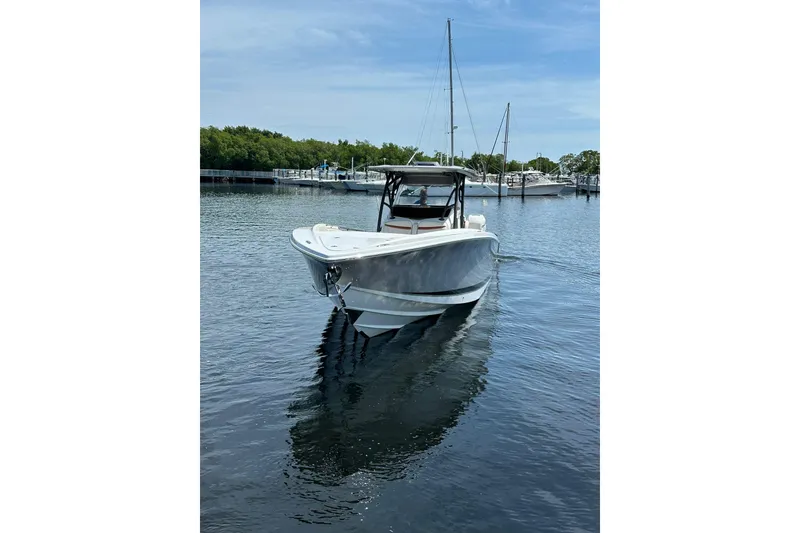 Slide: The Image of 2015 Nor-Tech 390 Sport Center Console boat on calm water, marina background. - 4