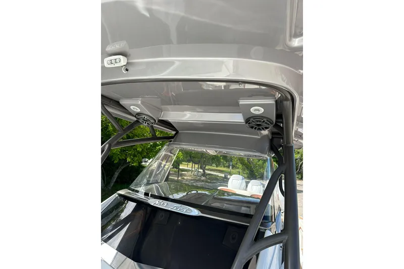 Slide: The Image of 2015 Nor-Tech 390 Sport Center Console boat with speakers and windshield, outdoor setting. - 7