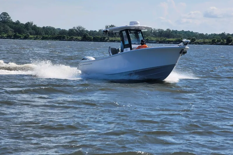 Slide: The Image of 2024 Sportsman Open 232 Center Console boat cruising on a scenic waterway. - 13