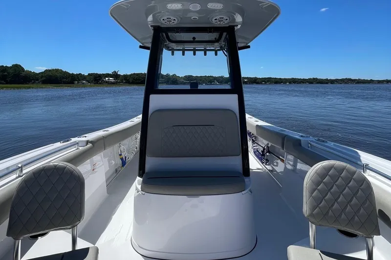 Slide: The Image of 2024 Sportsman Open 232 Center Console boat on calm water, featuring sleek seating and modern design. - 15