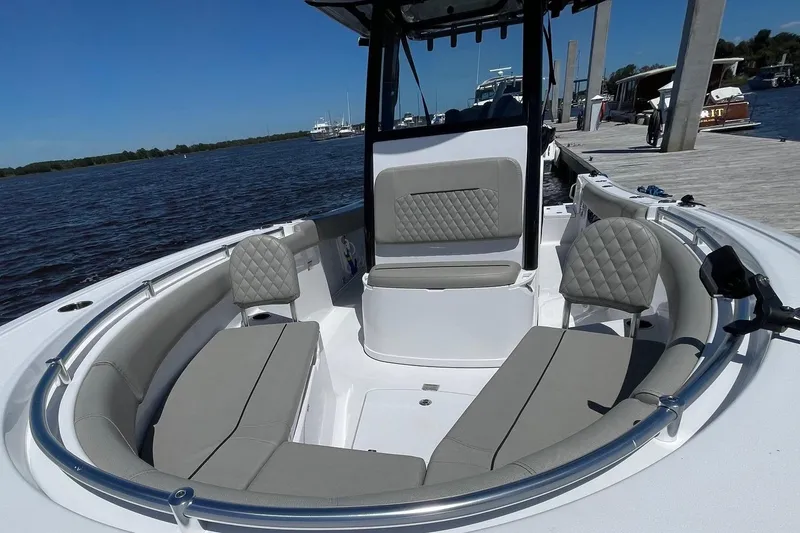 Slide: The Image of 2024 Sportsman Open 232 Center Console boat with spacious seating, docked by the water. - 23