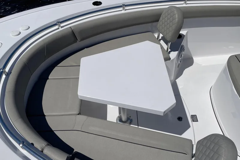 Slide: The Image of 2024 Sportsman Open 232 Center Console boat with cushioned seating and table. - 25