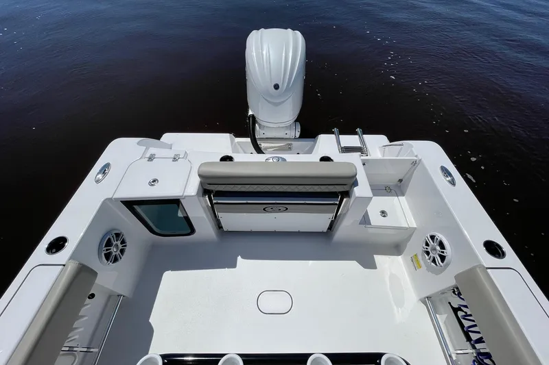Slide: The Image of 2024 Sportsman Open 232 Center Console boat interior with seating and motor, on calm water. - 29