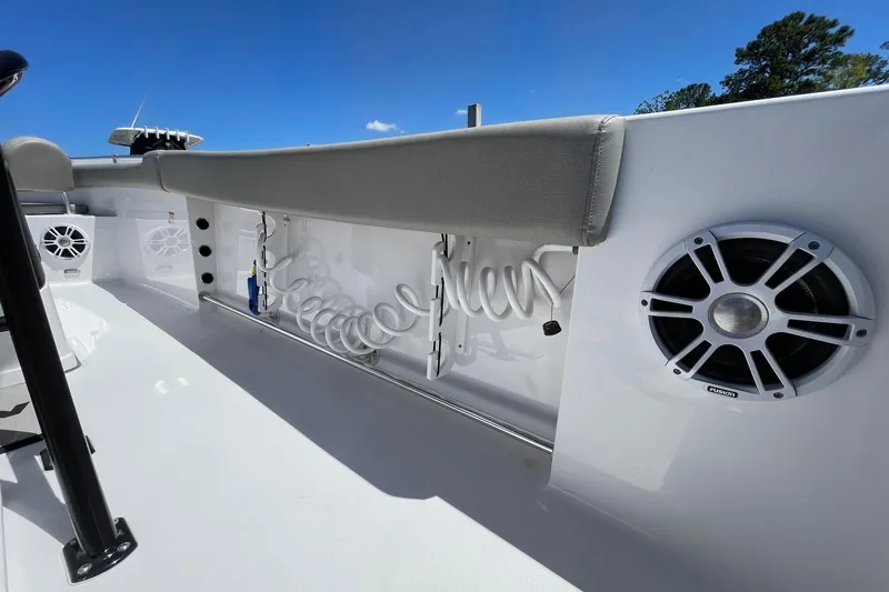 Slide: The Image of 2024 Sportsman Open 232 Center Console boat interior with speakers and coiled hose. - 36