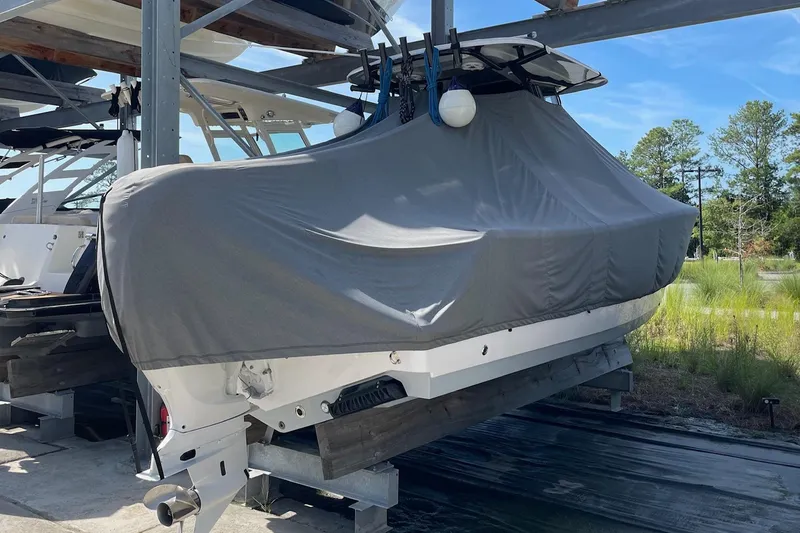 Slide: The Image of 2024 Sportsman Open 232 Center Console boat covered and stored outdoors. - 37