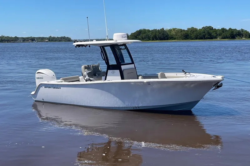 Slide: The Image of 2024 Sportsman Open 232 Center Console boat on calm water, clear sky background. - 4