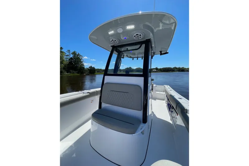 Slide: The Image of 2024 Sportsman Open 232 Center Console boat on a sunny day, river backdrop. - 58