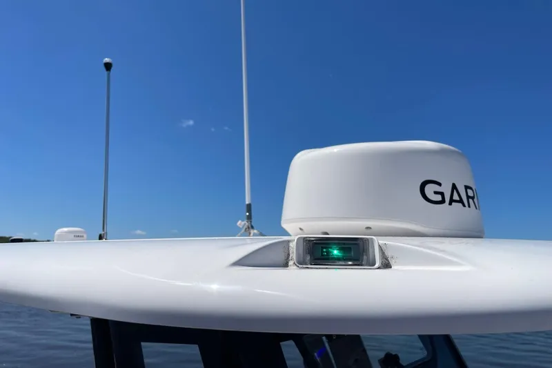 Slide: The Image of 2024 Sportsman Open 232 Center Console with Garmin radar against clear blue sky. - 59