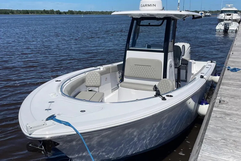 Slide: The Image of 2024 Sportsman Open 232 Center Console boat docked on calm water. - 6