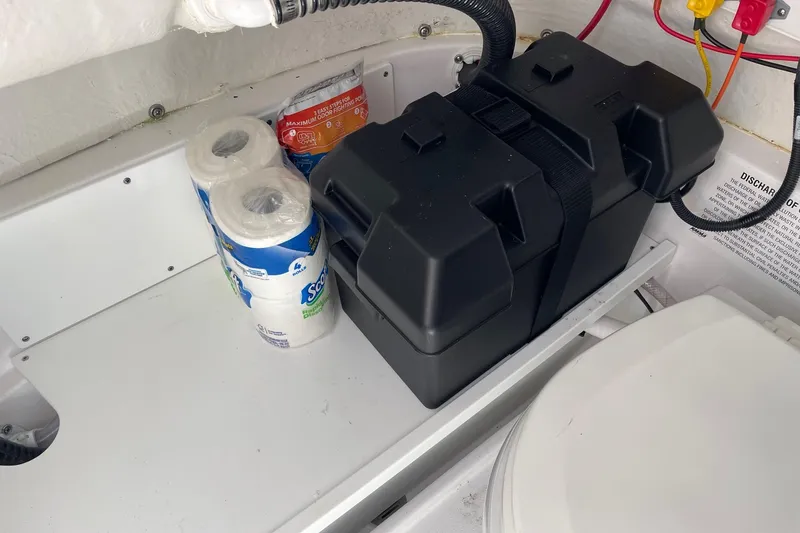 Slide: The Image of 2024 Sportsman Open 232 Center Console storage with battery box and toilet paper rolls. - 67