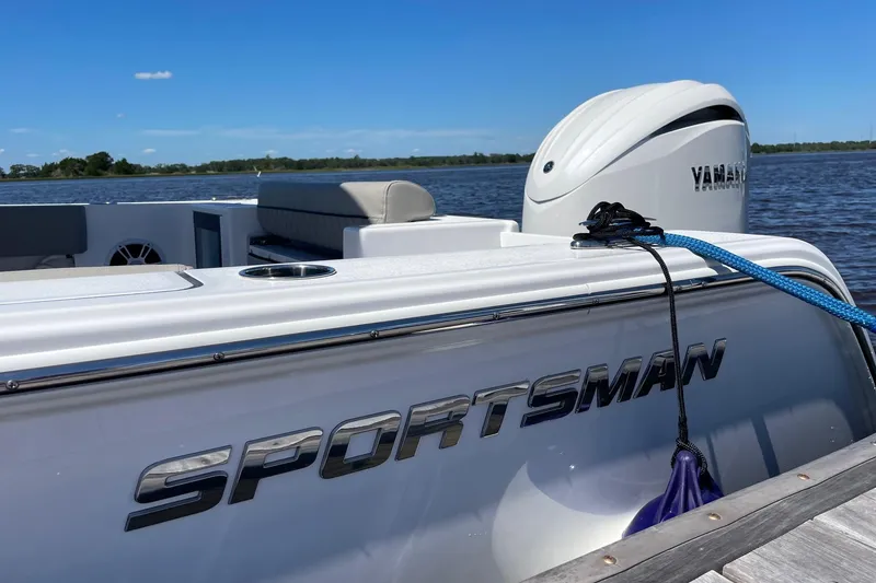 Slide: The Image of 2024 Sportsman Open 232 Center Console boat docked with Yamaha engine, under clear blue sky. - 74