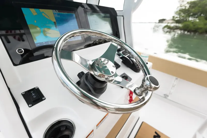 Slide: The Image of Manufacturer Provided Image: 2024 Sportsman Open 232 Center Console boat steering wheel and navigation screens. - 87